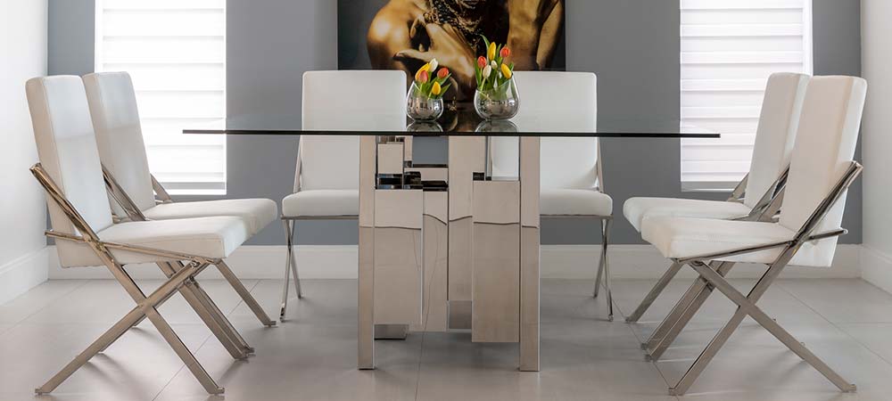 Modern dining room with a rectangular glass table and six sleek white chairs, offering a stylish and functional setup for contemporary spaces