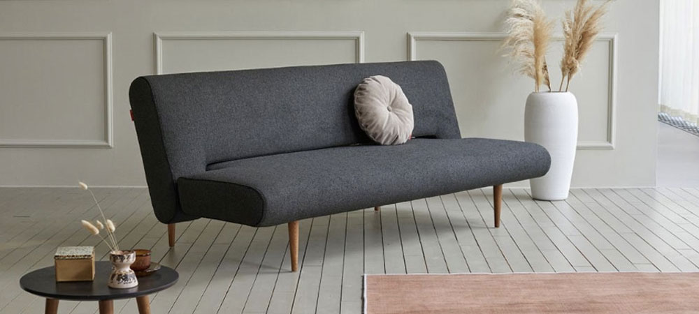 beige Fabric Sectional in a modern living room combined with a marble top funcional cofee table with bright orange accents and an orange Lounge chair