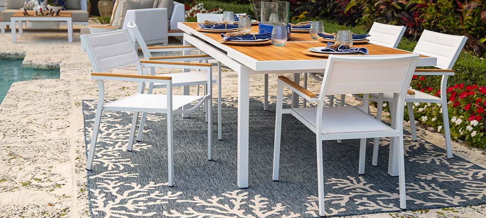 Beautiful outdoor dining set with a blue rug with coral design